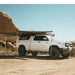 eezi-awn-dragonfly-180-open-beige-rear-side-view-on-toyota-tundra-in-nature