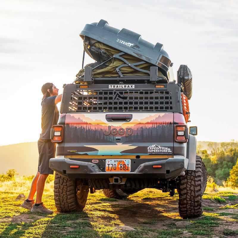 23zero-armadillo-x2-hard-shell-roof-top-tent-closed-side-view-on-jeep-gladiator-with-person-opening-tent-in-nature