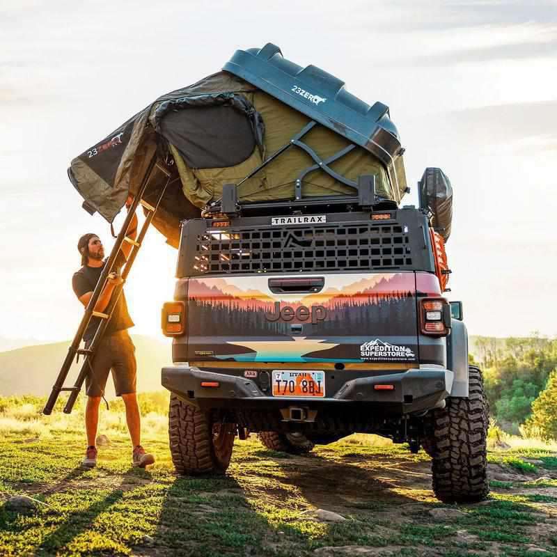 23zero-armadillo-x2-hard-shell-roof-top-tent-open-side-view-on-jeep-gladiator-with-ladder and-person-closing-tent-in-nature