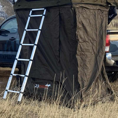 23zero-breezeway-and-weekender-roof-top-tent-annex-open-front-corner-view-on-vehicle-with-ladder-in-nature