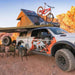 23zero-kabari-2-0-hard-shell-roof-top-tent-open-rear-corner-view-on-ram-1500-with-with-awning-and-camping-chairs-in-terrain