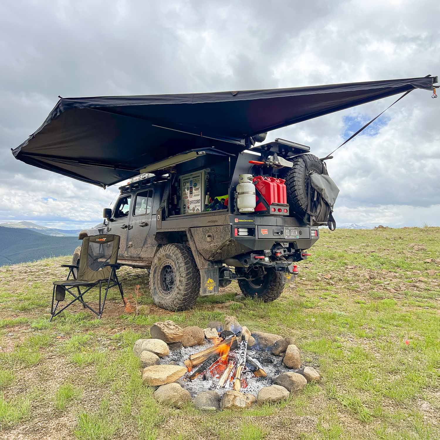 23zero-peregrine-pro-180-awning-open-rear-corner-view-on-jeep-gladiator-with-camping-chair-in-nature