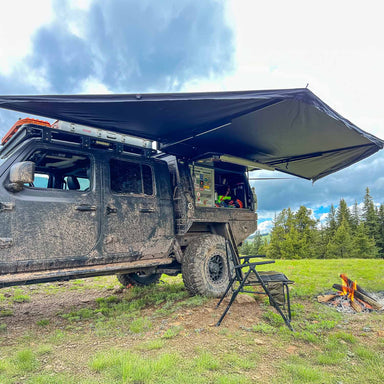 23zero-peregrine-pro-180-awning-open-side-view-on-jeep-gladiator-with-camping-chair-in-nature