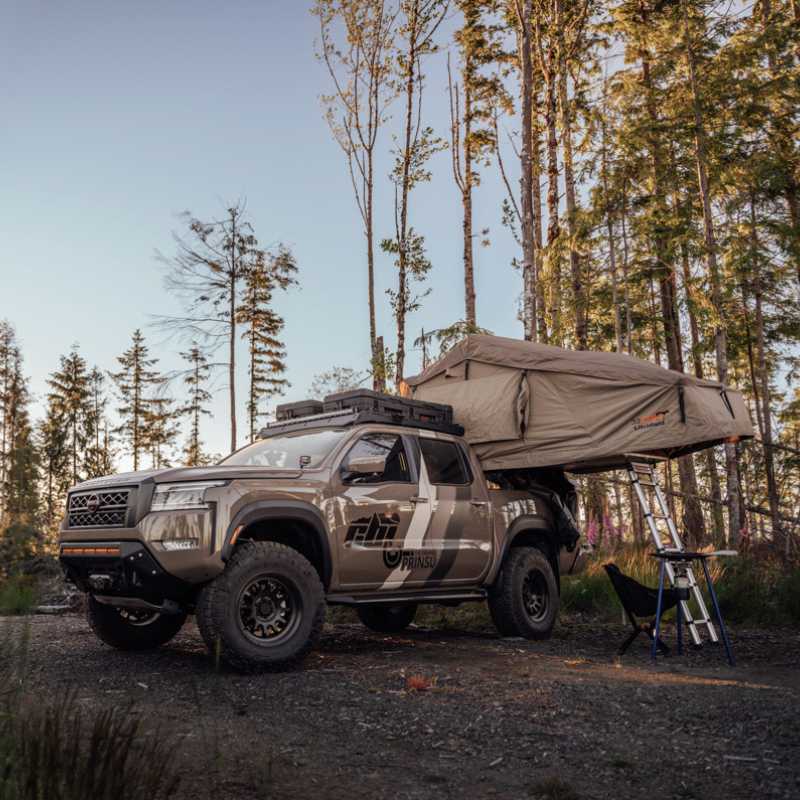 cbi-3rd-gen-nissan-frontier-bed-bars-2022-front-corner-view-with-opened-roof-top-tent-in-nature