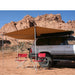 eezi-awn-bat-270-awning-beige-open-rear-side-view-ontop-of-land-cuiser-in-terrain-with-red-folding-chairs