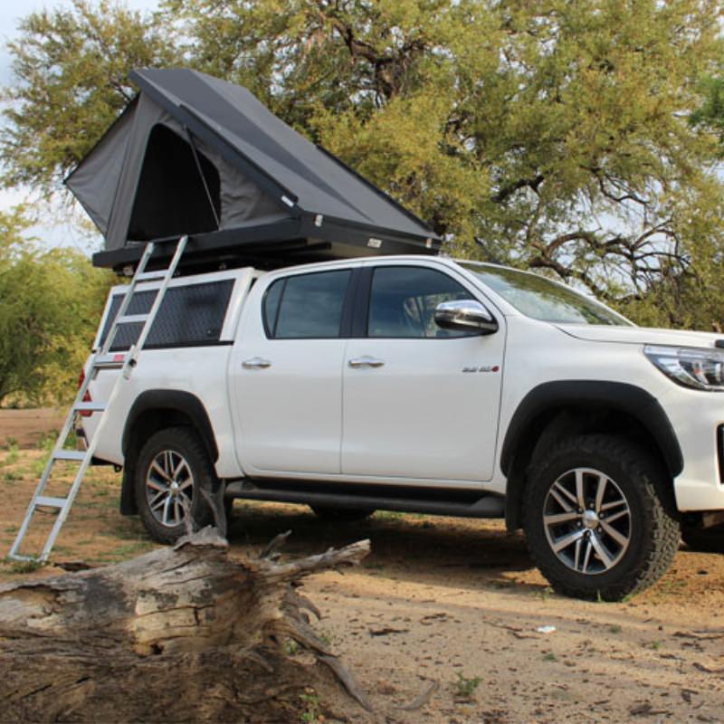 eezi-awn-blade-hard-shell-roof-top-tent-open-front-corner-view-on-vehicle-with-extended-ladder-in-nature