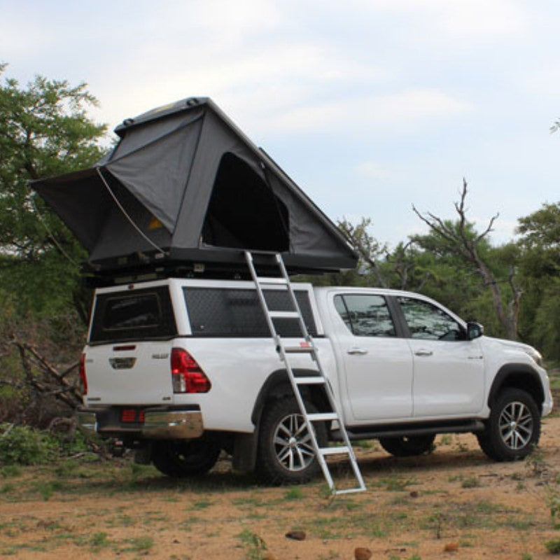eezi-awn-blade-hard-shell-roof-top-tent-open-rear-view-on-vehicle-with-extended-ladder-in-forest