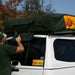 eezi-awn-jazz-soft-shell-roof-top-tent-closed-rear-corner-view-on-vehicle-with-person-in-nature