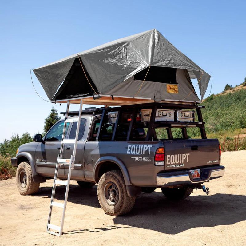 eezi-awn-jazz-soft-shell-roof-top-tent-gray-open-rear-corner-view-on-vehicle-with-ladder-in-nature