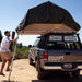 eezi-awn-jazz-soft-shell-roof-top-tent-open-rear-view-on-vehicle-with-person-on-ladder