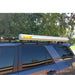 eezi-awn-k9-roof-rack-for-toyota-4runner-5th-gen-on-white-background-side-view-with-awning-in-farm