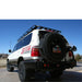 eezi-awn-k9-roof-rack-for-toyota-land-cruiser-100-series-rear-corner-view-with-spare-tire-in-nature