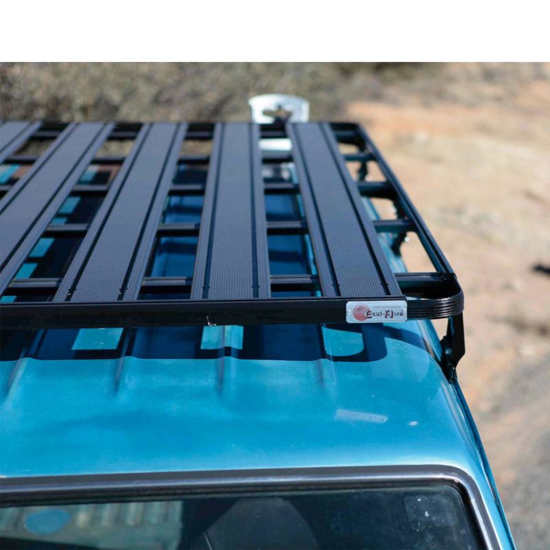 eezi-awn-k9-roof-rack-for-toyota-land-cruiser-60-close-up-view-with-brand-logo-on-blue-land-cruiser-in-terrain