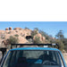 eezi-awn-k9-roof-rack-for-toyota-land-cruiser-60-front-view-with-rocky-hill-on-background-on-blue-land-cruiser-in-nature