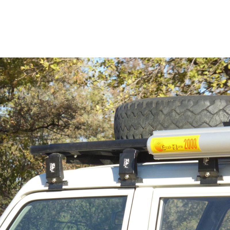 eezi-awn-k9-roof-rack-for-toyota-land-cruiser-70-series-close-up-view-with-awning-and-spare-tire-in-nature