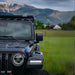 eezi-awn-k9-roof-rack-kit-for-jeep-gladiator-close-up-view-with-mountain-and-houses-at-the-back-in-nature