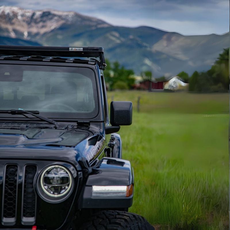 eezi-awn-k9-roof-rack-kit-for-jeep-gladiator-close-up-view-with-mountain-and-houses-at-the-back-in-nature