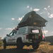 eezi-awn-sabre-hard-shell-roof-top-tent-open-rear-corner-view-on-vehicle-with-extended-ladder-in-nature
