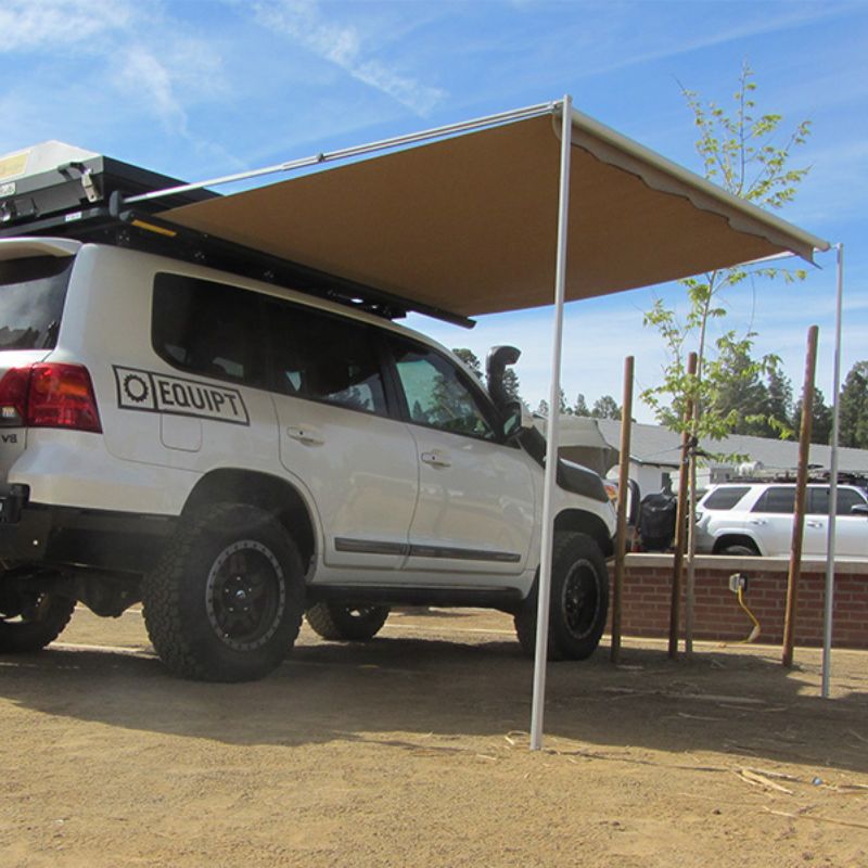 eezi-awn-series-2000-awning-beige-open-rear-corner-view-in-black-hardcase-on-land-cruiser-in-parking-area