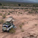 eezi-awn-series-3-roof-top-tent-beige-open-rear-corner-view-on-land-rover-defender-in-desert-landscape-with-person-outside