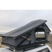 eezi-awn-stealth-hard-shell-roof-top-tent-open-front-corner-close-up-view-with-pitched-rainfly-on-toyota-tundra-in-desert