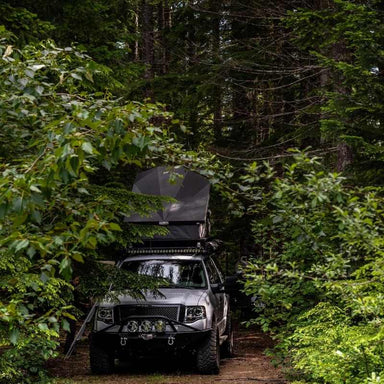 eezi-awn-stealth-hard-shell-roof-top-tent-open-front-view-on-ford-explorer-in-forest