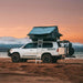 eezi-awn-sword-hard-shell-roof-top-tent-open-side-view-on-vehicle-in-with-ladder-in-sandy-beach