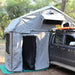eezi-awn-xklusiv-soft-shell-roof-top-tent-gray-open-front-view-on-vehicle-with-extended-room-in-forest