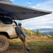 freespirit-recreation-270-awning-driver-side-open-side-view-on-vehicle-in-nature-with-person-enjoying-the-view