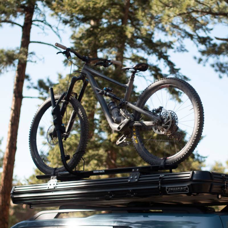 freespirit-recreation-aspen-v2-xl-hard-shell-roof-top-tent-black-closed-on-top-of-vehicle-with-bike-in-nature
