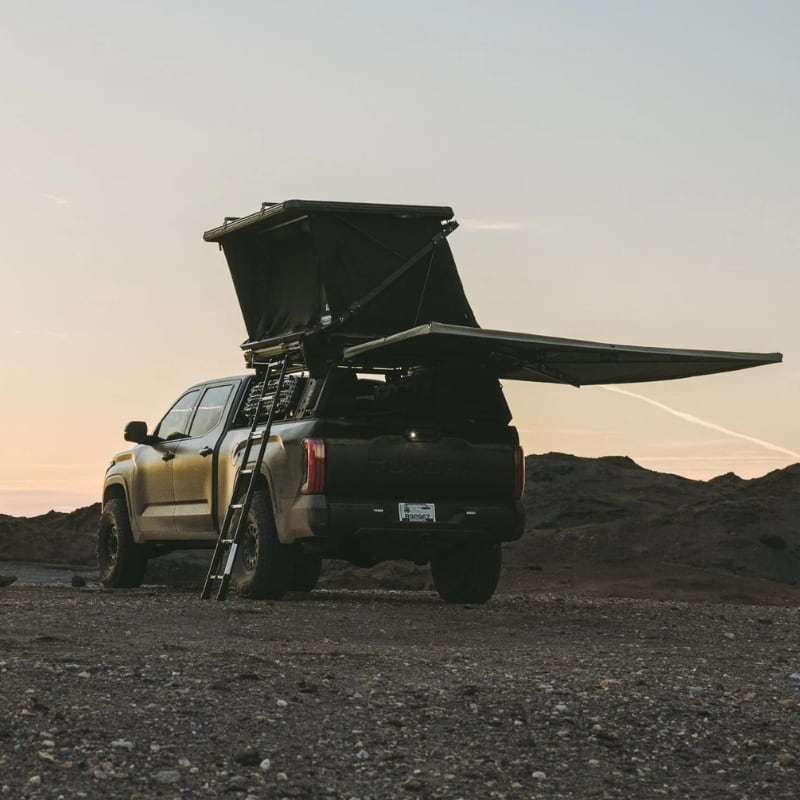 freespirit-recreation-evolution-v2-hard-shell-roof-top-tent-black-open-rear-corner-view-on-toyota-tundra-in-the-mountains