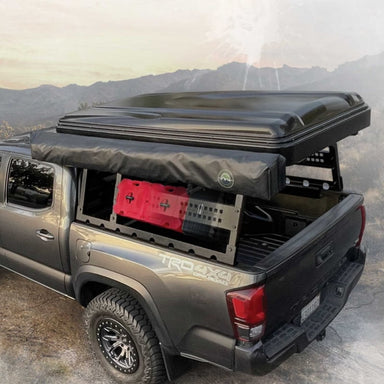 overland-vehicle-systems-discovery-rack-side-view-on-toyota-tacoma-with-roof-top-tent-and-awning-in-nature