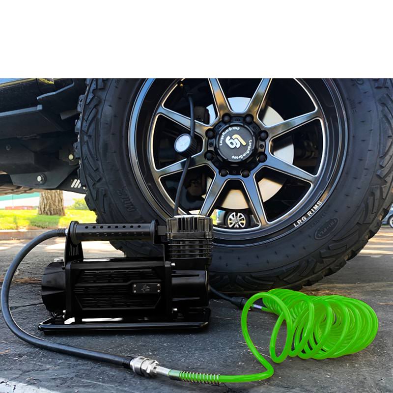 overland-vehicle-systems-egoi-5.6-cfm-air-compressor-system-inflating-a-black-tri-fly-tire-using-the-24-feet-green-coiled-hose-outdoor