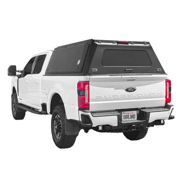 overland-vehicle-systems-expedition-truck-cap-black-for-2023-2024_-ford-f250-f350-rear-corner-view-on-natural-backgound