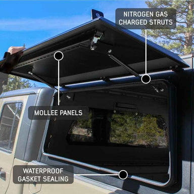 overland-vehicle-systems-expedition-truck-cap-black-open-close-up-view-on-vehicle-in-terrain
