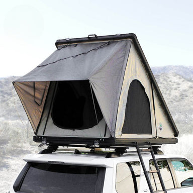 overland-vehicle-systems-ld-tmon-clamshell-aluminum-hard-shell-roof-top-tent-tan-open-front-corner-view-on-vehicle-in-nature