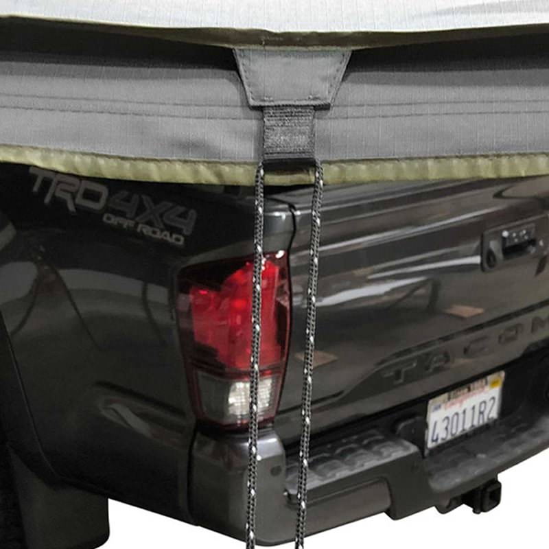 overland-vehicle-systems-nomadic-awning-180-dark-gray-open-rear-corner-view-on-toyota-tacoma-showing-tie-down
