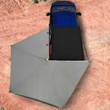 overland-vehicle-systems-nomadic-awning-270-lt-driver-side-dark-gray-open-drone-view-on-ford-ranger-in-desert