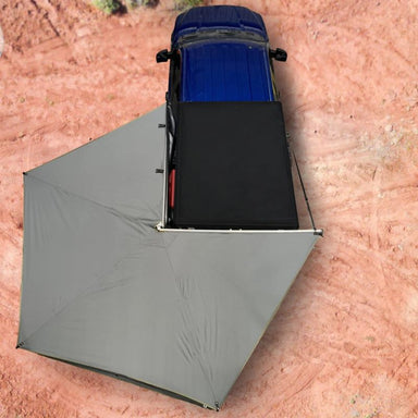 overland-vehicle-systems-nomadic-lt-270-awning-with-walls-dark-gray-open-driver-side-drone-view-on-ford-ranger-in-desert