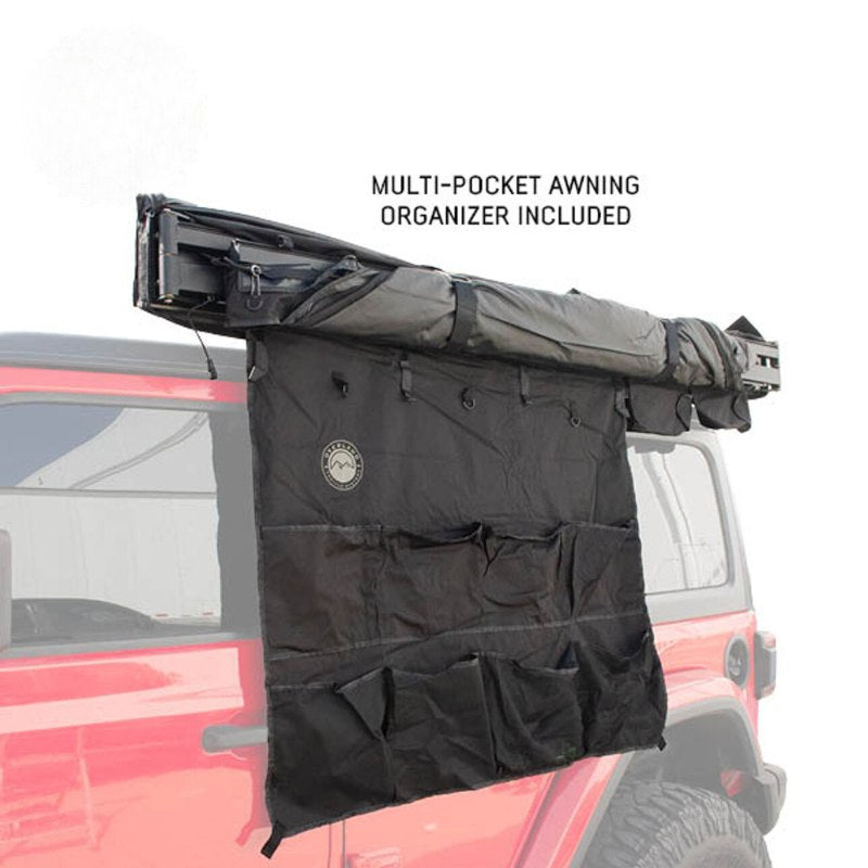 overland-vehicle-systems-xd-nomadic-180-awning-with-lights-and-black-out-closed-front-corner-view-with-organizer-on-white-background