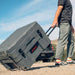 roam-132l-rolling-rugged-case-slate-front-corner-view-with-person-in-nature