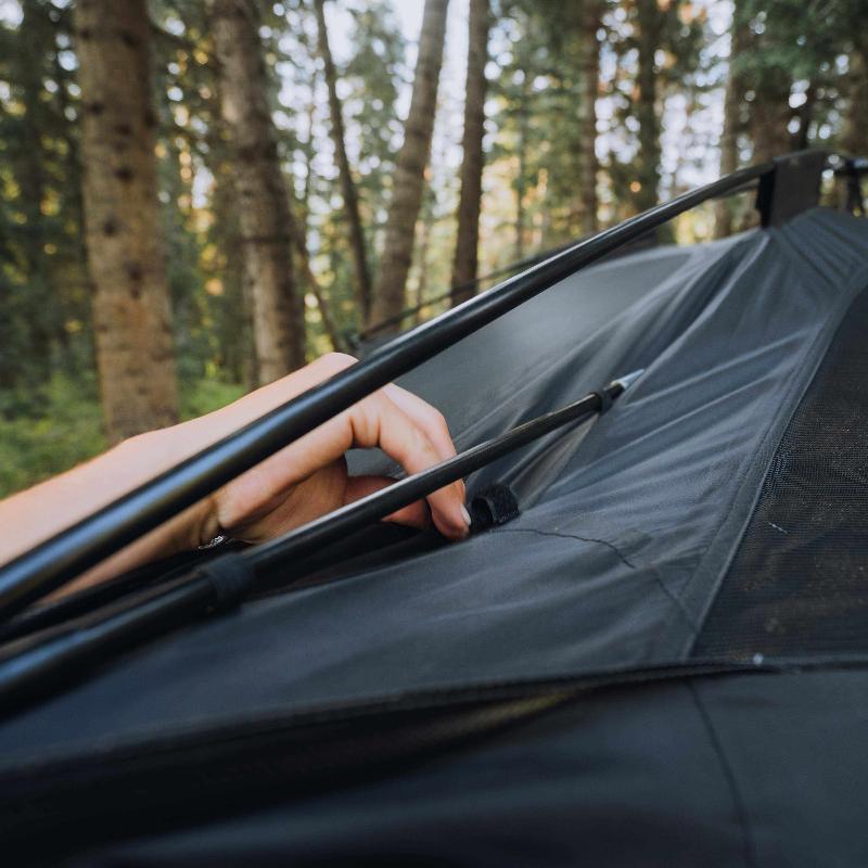 roam-drifter-tent-open-close-up-view-with-person-fixing-tent-poles-in-nature