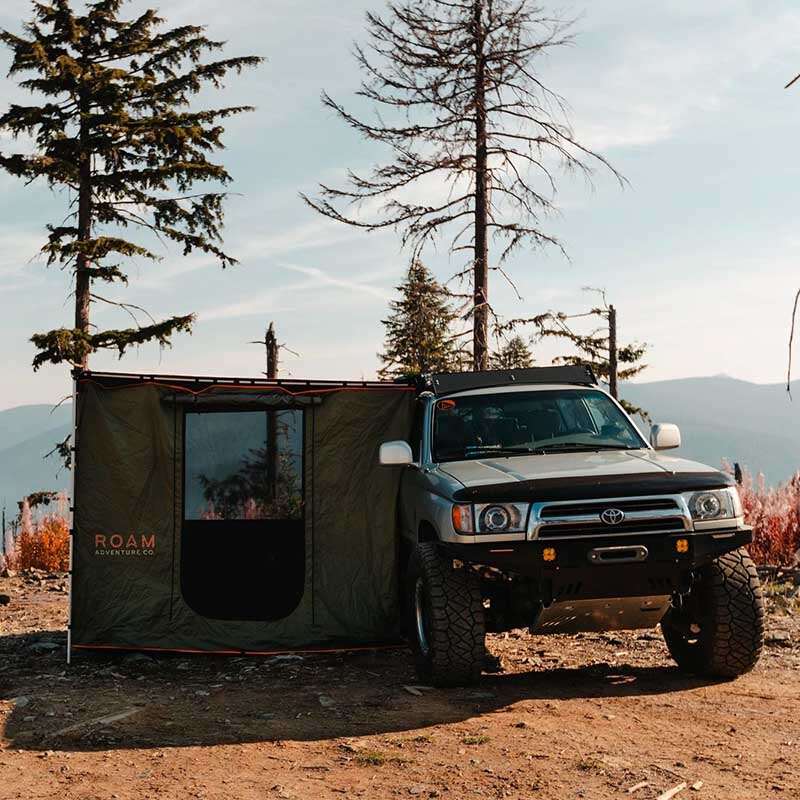 roam-standard-awning-room-forest-green-hyper-orange-side-view-on-vehicle-in-nature