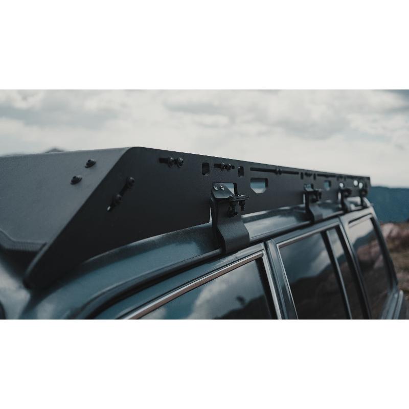 sherpa-mineral-roof-rack-for-1980-1990-land-cruiser-60-series-front-corner-view-with-mounting-hardware-in-terrain