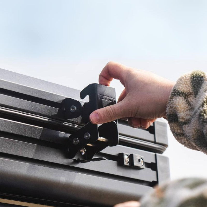 tentbox-cargo-2-hard-shell-roof-top-tent-closed-close-up-view-with-hand-on-lock-on-nature