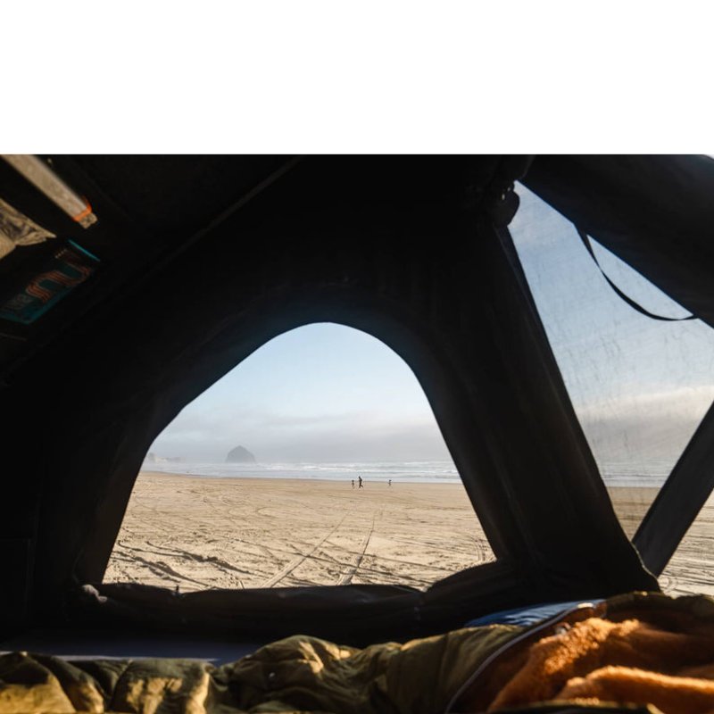 tentbox-cargo-2-hard-shell-roof-top-tent-midnight-gray-open-interior-view-with-mesh-windows-at-the-beach