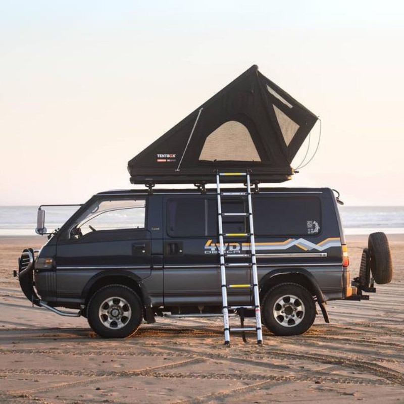 tentbox-cargo-2-hard-shell-roof-top-tent-midnight-gray-open-side-view-on-mitsubishi-delica-with-ladder-at-the-beach