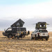 tentbox-cargo-2-hard-shell-roof-top-tent-midnight-gray-open-side-view-on-mitsubishi-delica-with-persons-and-tentbox-classic-2-on-subaru-outback-at-the-beach