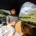 tentbox-cargo-hard-shell-roof-top-tent-black-open-interior-view-with-person-inside-in-nature