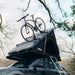tentbox-cargo-hard-shell-roof-top-tent-black-open-rear-corner-view-on-car-with-bike-on-railings-in-nature